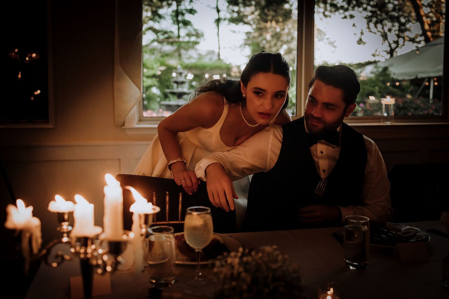 Romantic candlelit moment between newlyweds at their reception dinner.