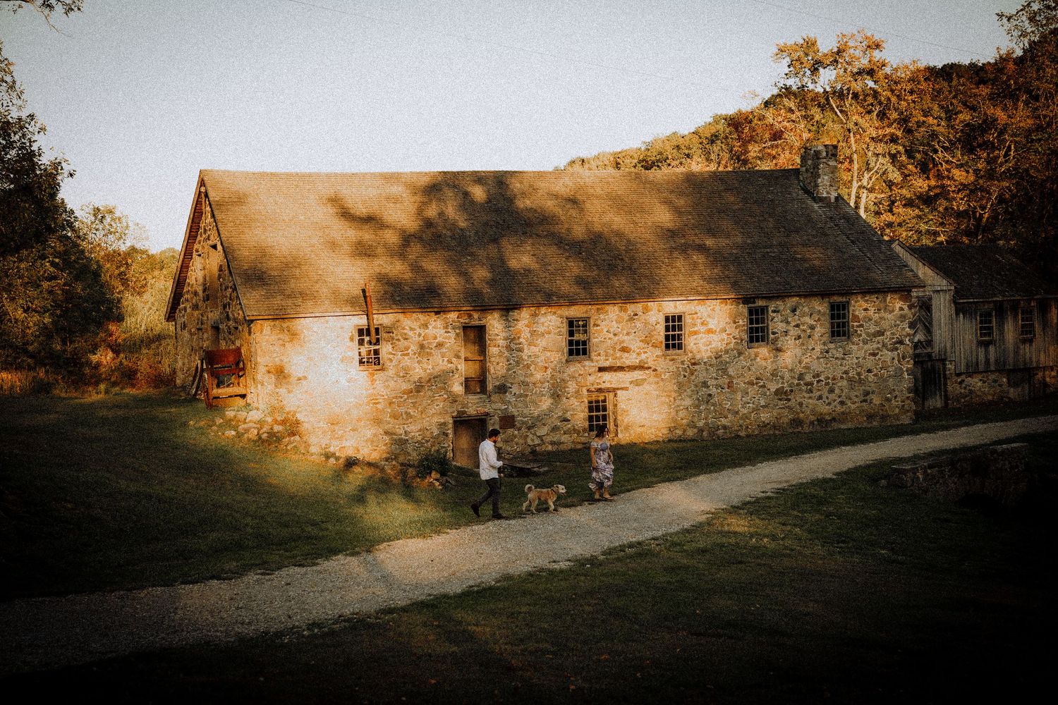 A rustic stone building with a bicycle parked outside during golden hour sunset.