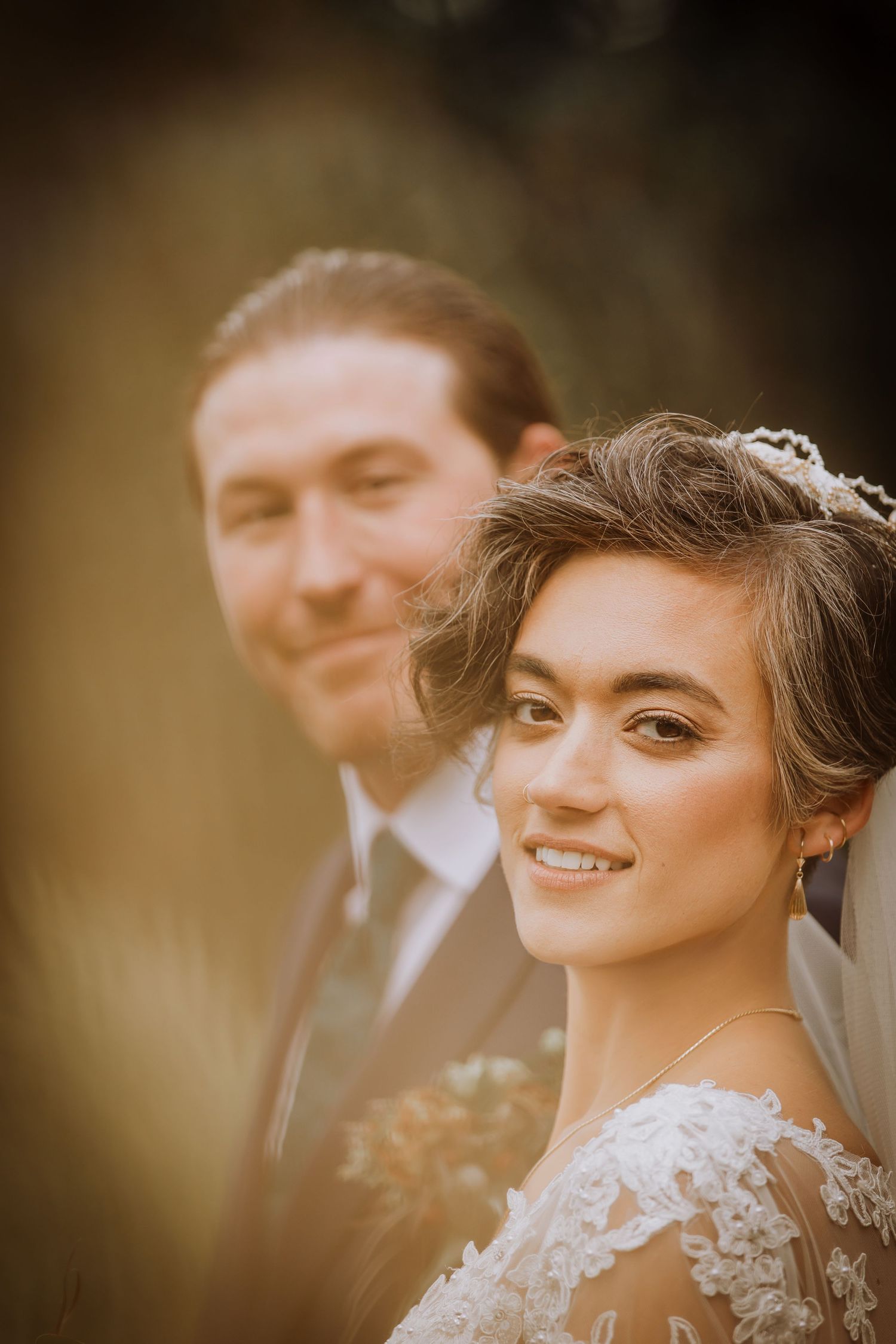 Close-up profile shot of a bride wearing a lace wedding dress and delicate hair accessories.