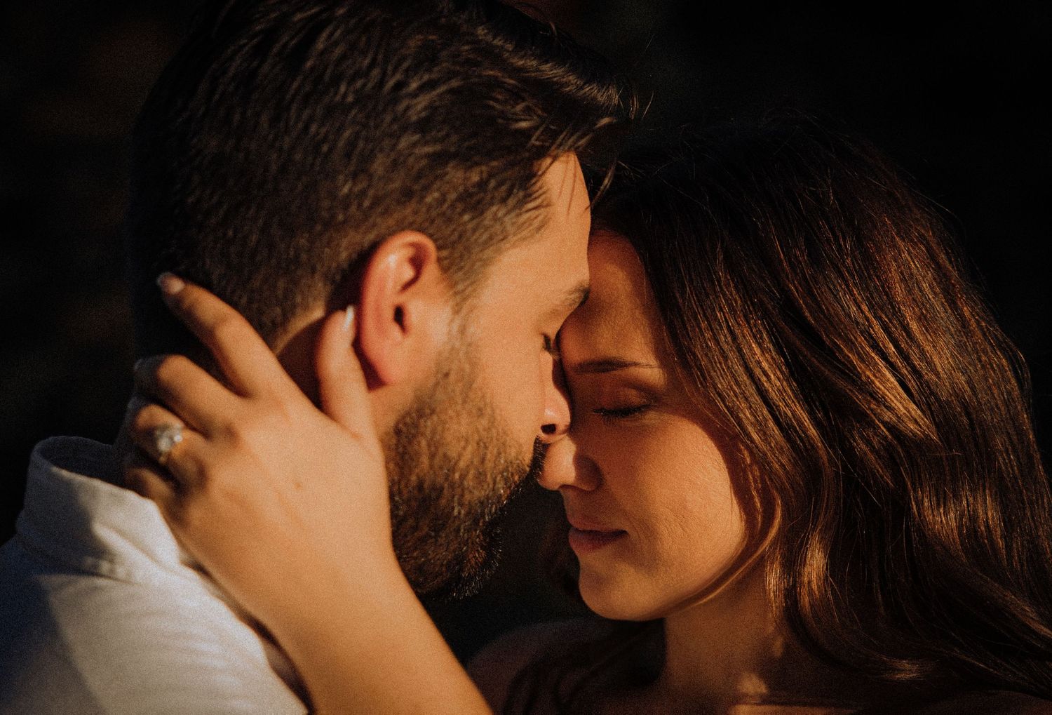 Romantic close-up portrait of a tender moment in warm lighting.