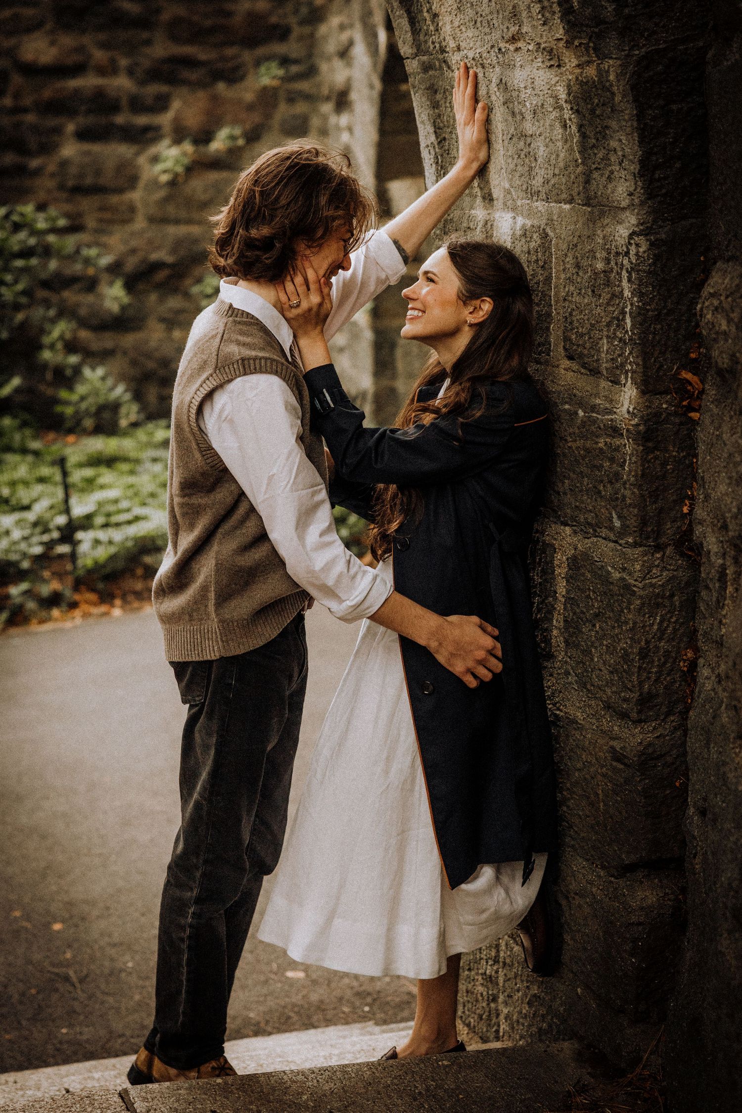 A romantic moment against stone walls with dramatic lighting and vintage styling.