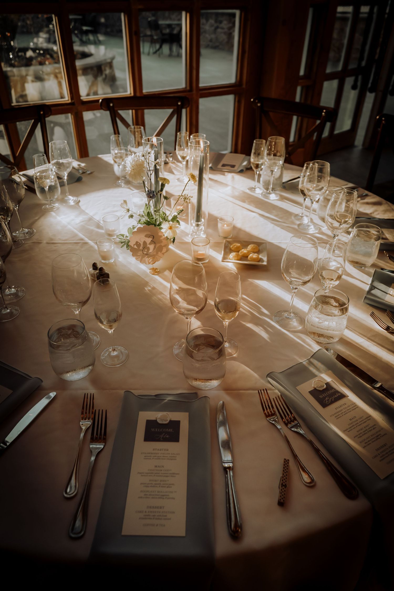 Elegant wedding table setting with wine glasses, candles and place settings in warm lighting.Editorial and Cinematic Wedding photos