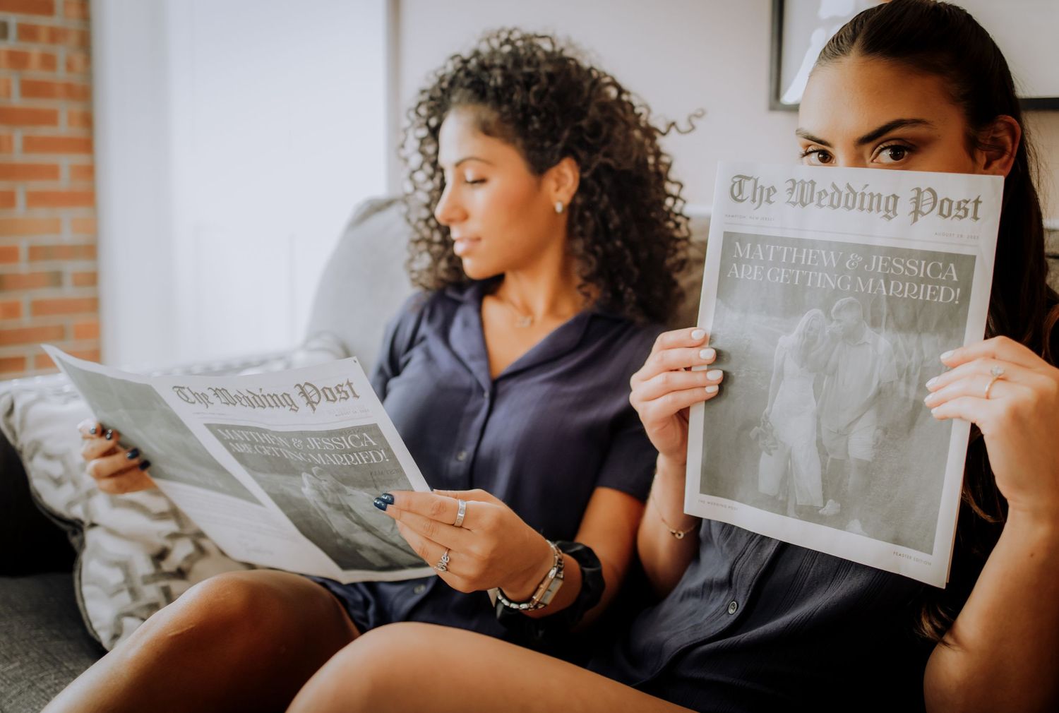 Two friends relaxing on a couch while reading The Wedding Post newspaper.Editorial and Cinematic Wedding photos