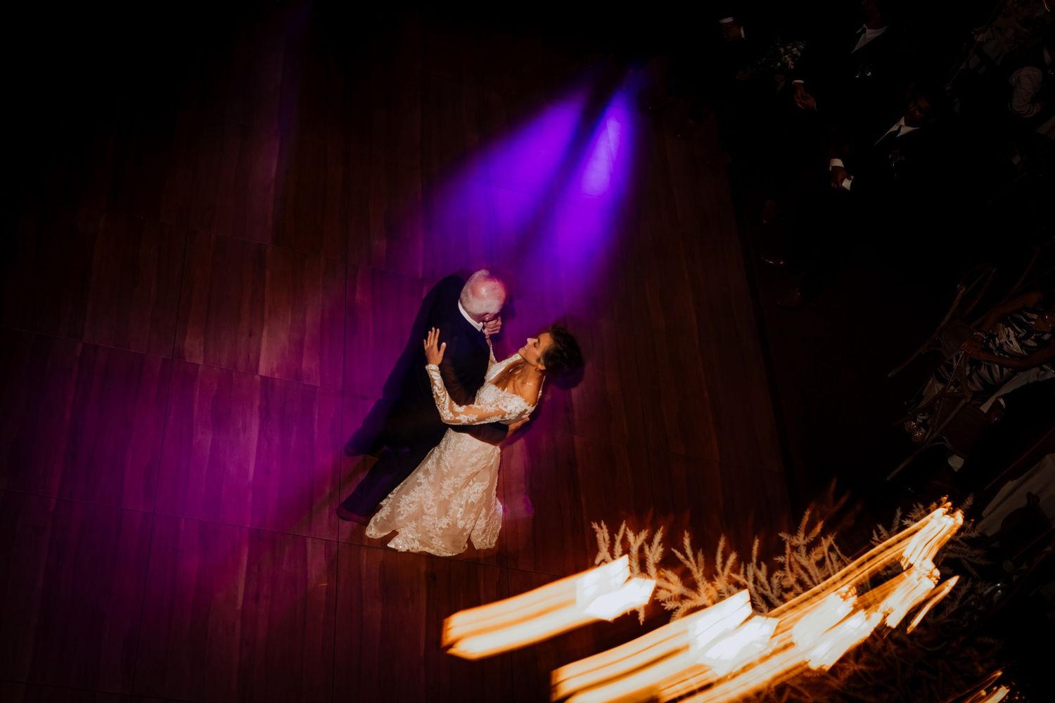 Purple-lit dance floor with dramatic lighting effects at wedding reception.