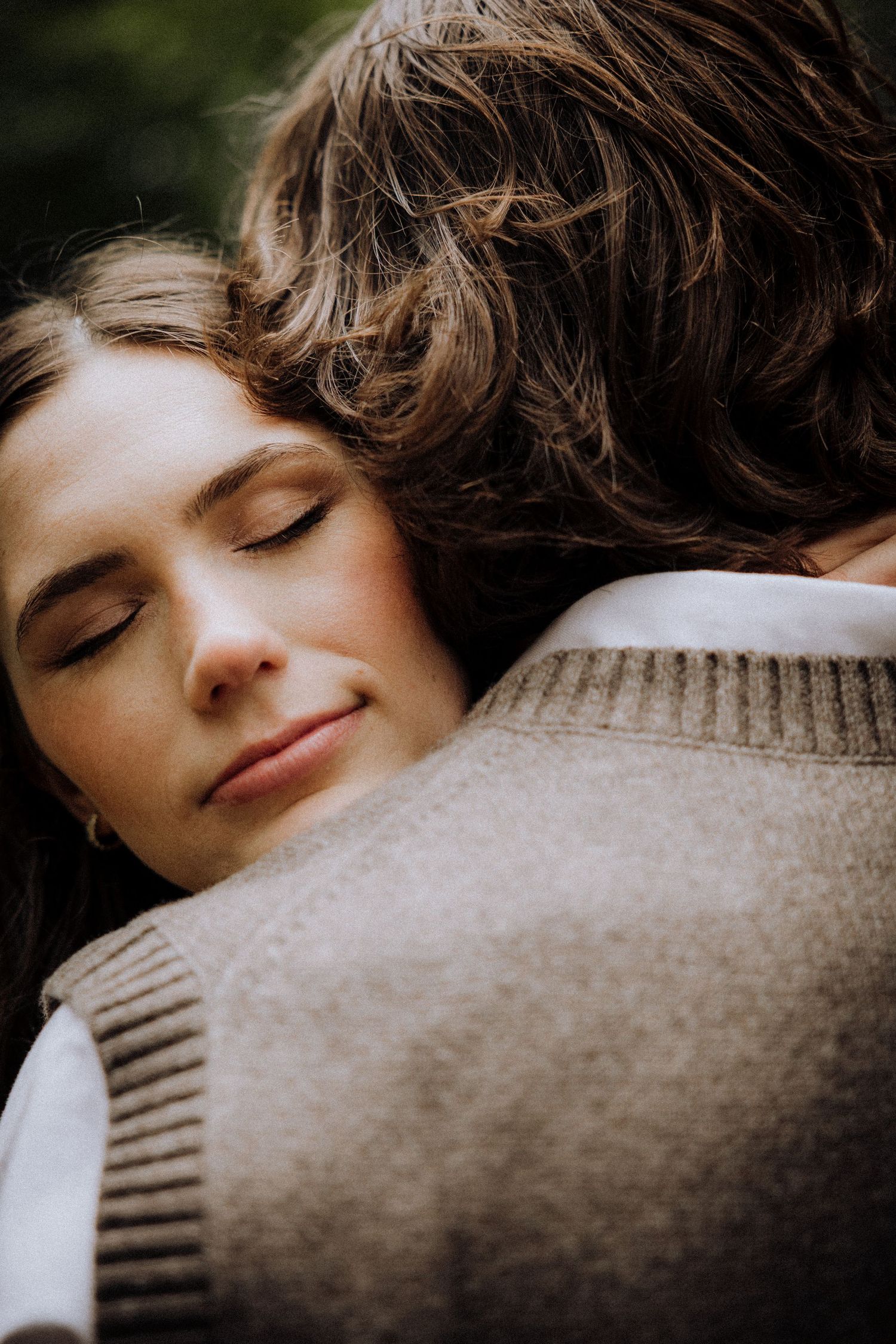 Peaceful embrace captured in warm tones against a beige sweater.