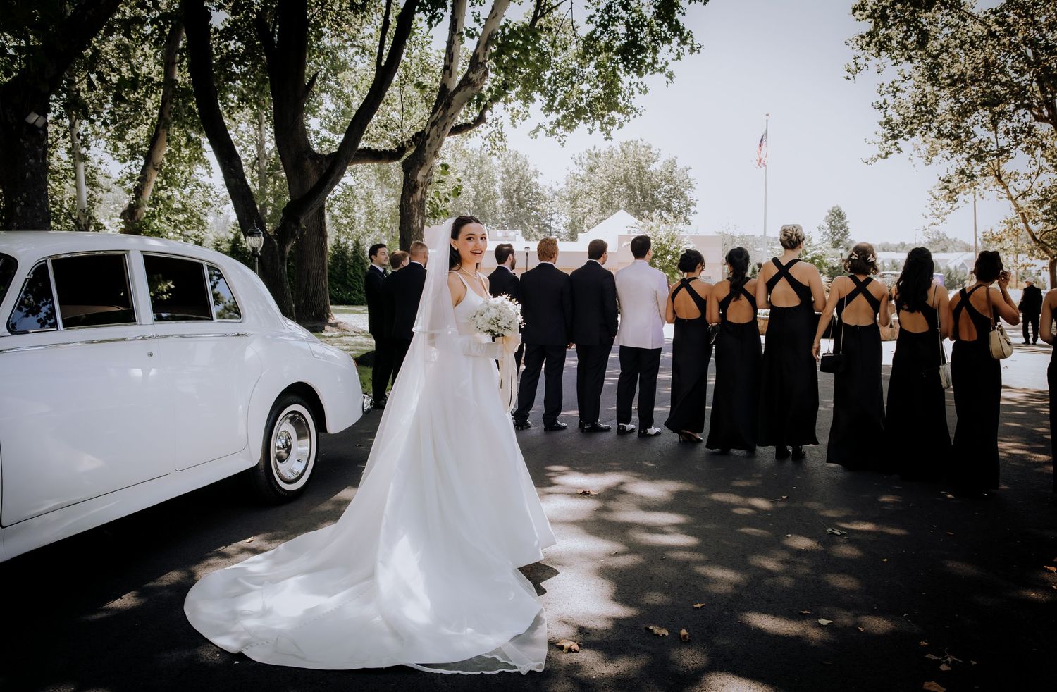 Panoramic view of outdoor wedding ceremony with guests gathered under trees and clear sky.Editorial and Cinematic Wedding photos