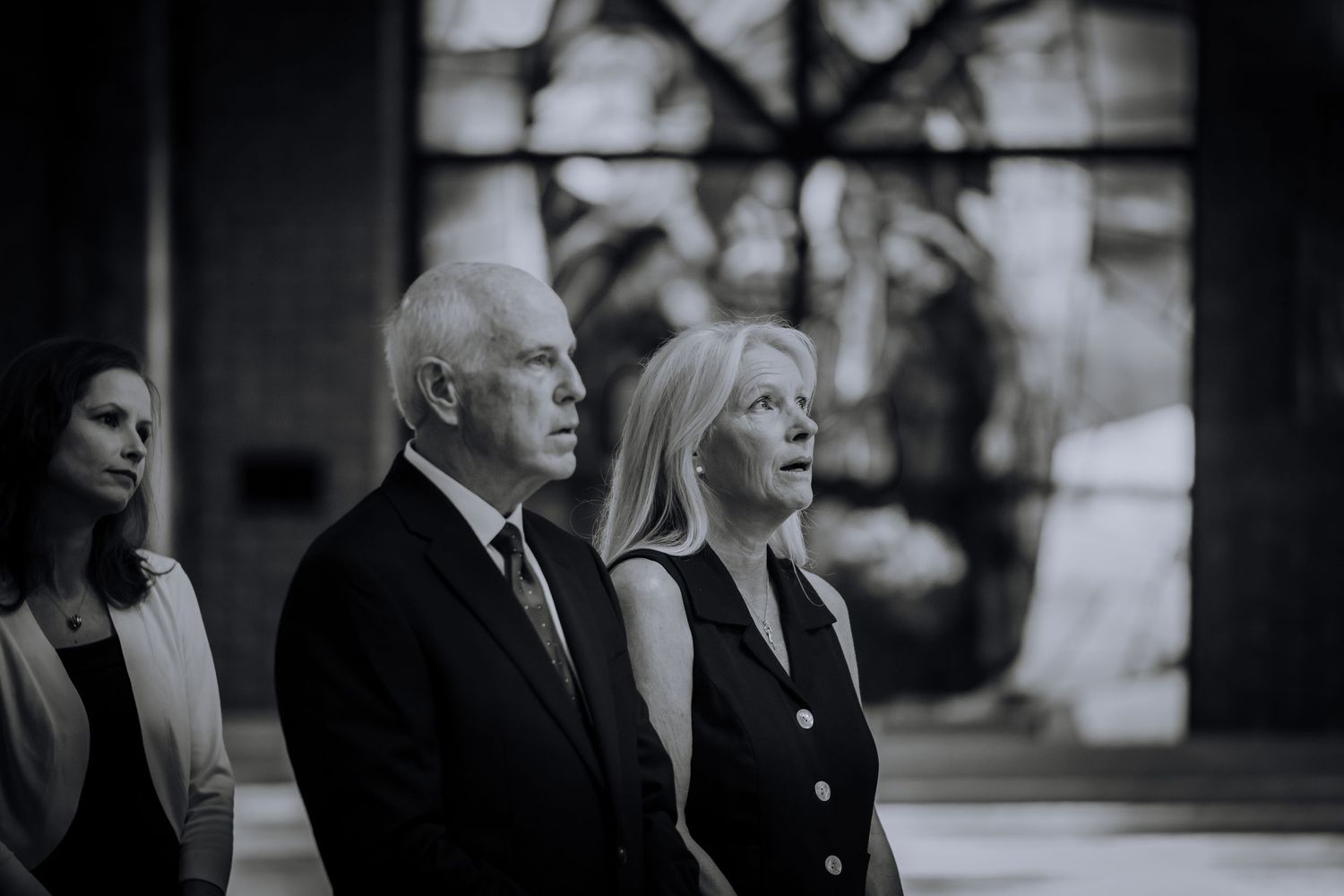 Wedding guests in formal attire gather for a candid black and white photo.Editorial and Cinematic Wedding photos