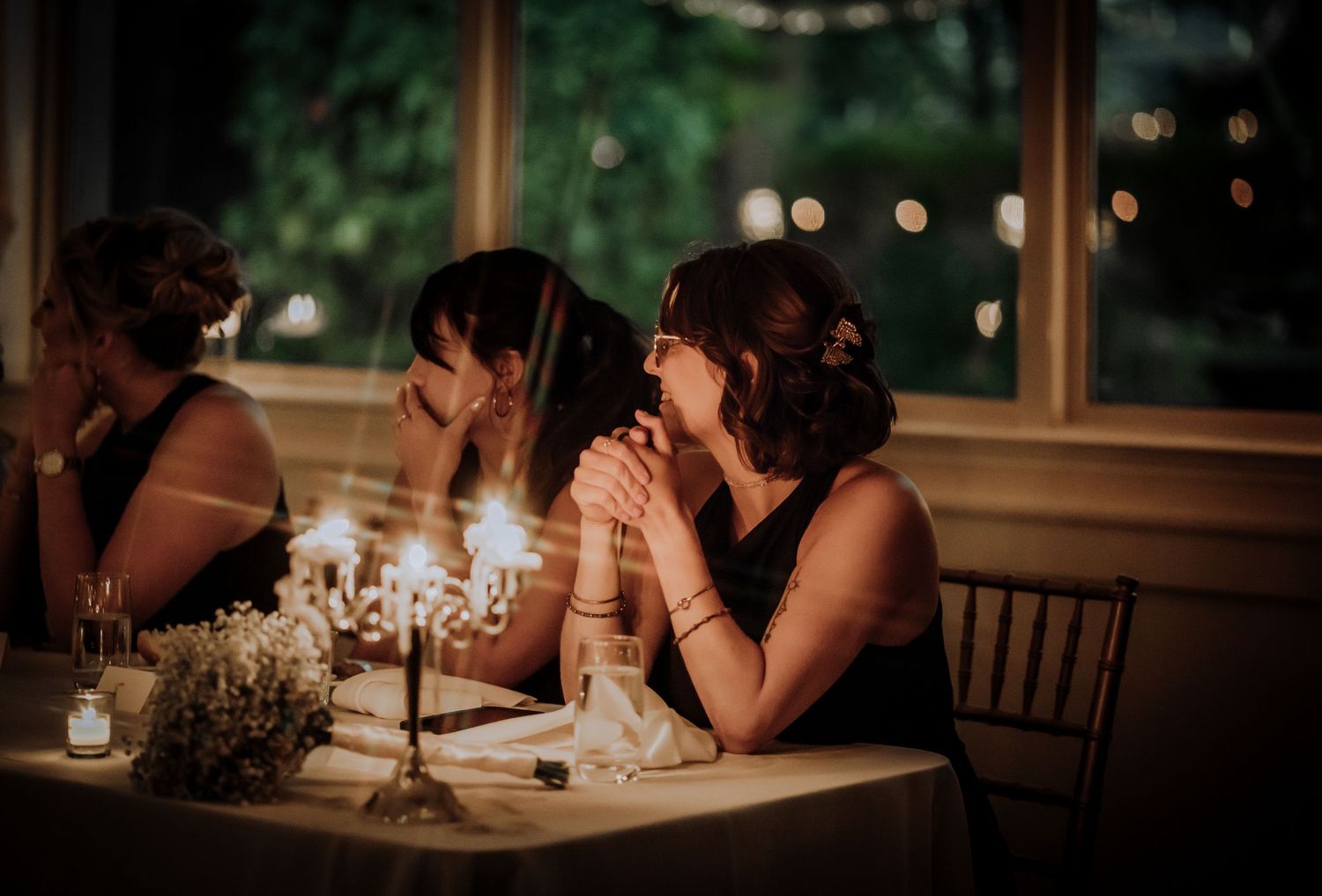 Intimate candlelit wedding reception scenes with guests at tables.