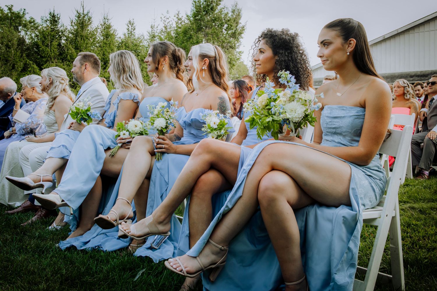 Wedding guests in light blue attire seated outdoors for ceremony.
