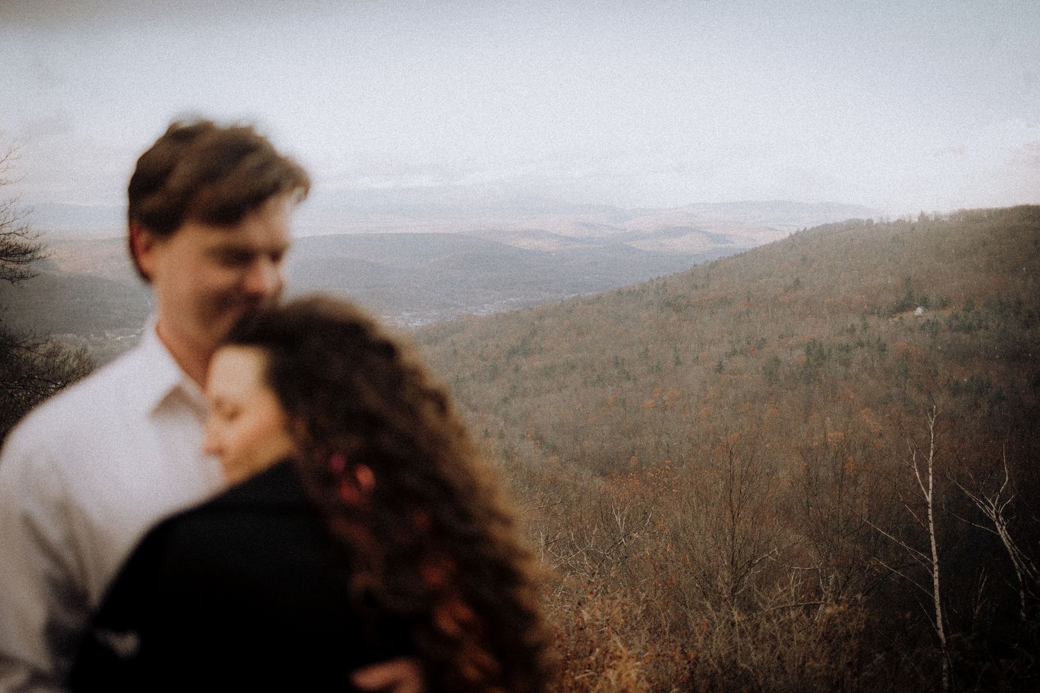 Panoramic mountain landscape with couple in romantic embrace.