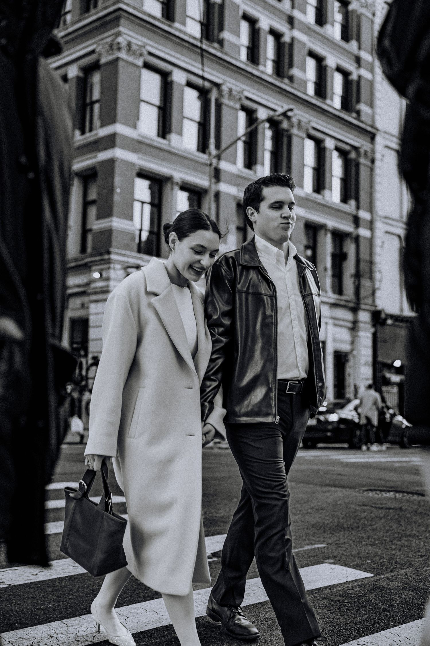 Couple strolling down an urban street in black and white photography.