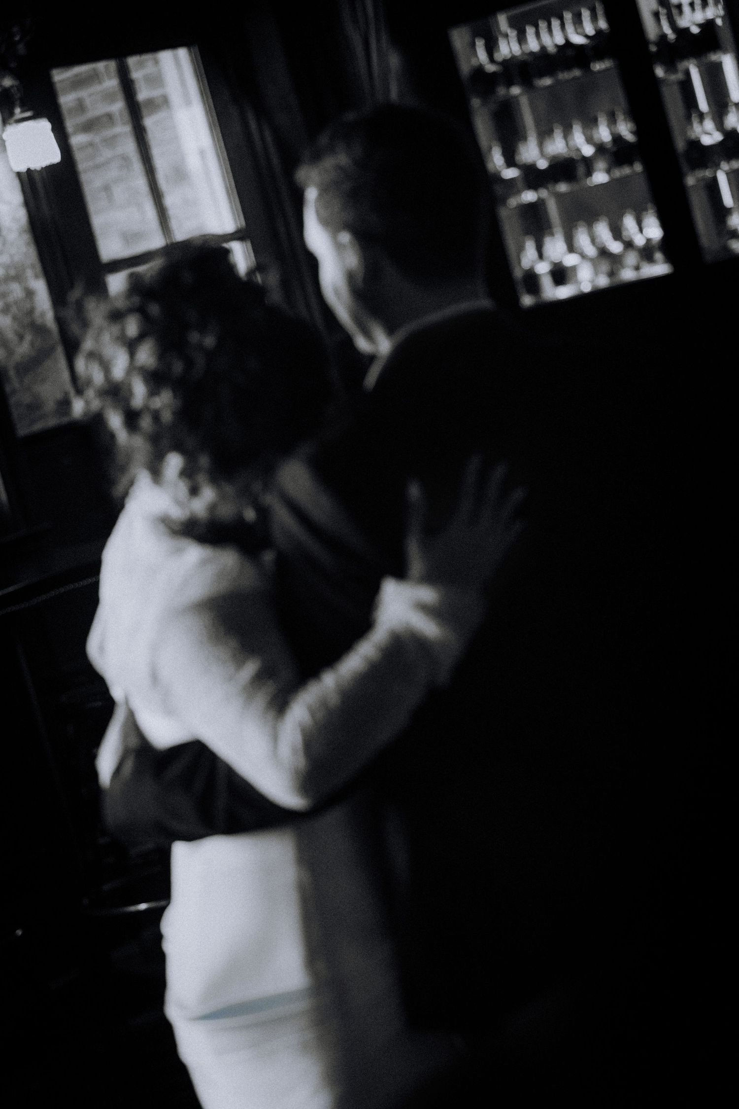 downtown-los-angelesBlack and white photo of a couple sharing a romantic dance embrace in a dimly lit venue with wine glasses in background.