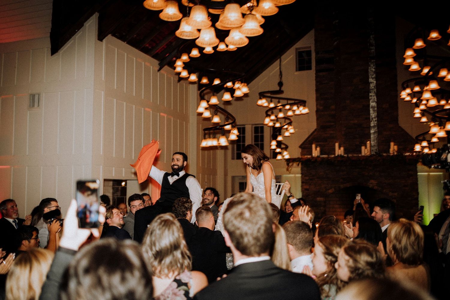 Wedding reception venue with string lights creating a warm atmosphere for dancing guests.