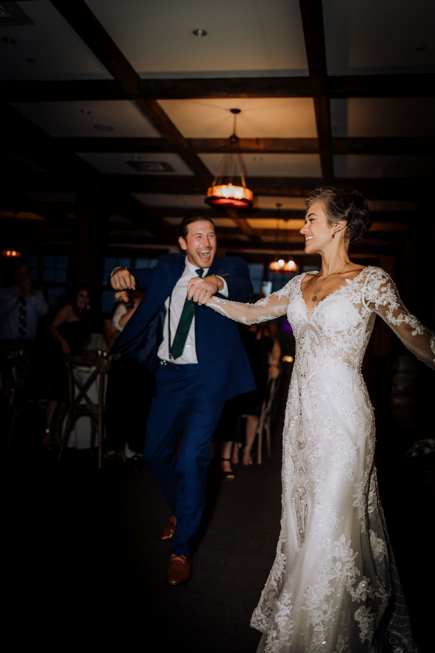 Wedding celebration with dancing and joyful moments in a dimly lit reception venue.