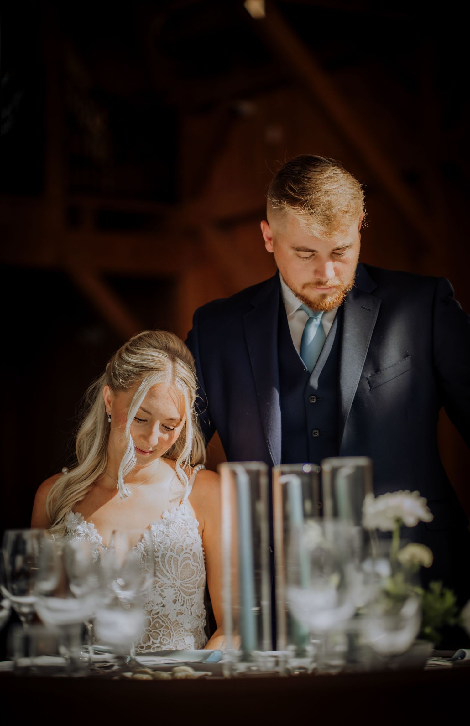Intimate moment captured at wedding reception dinner table in moody lighting.Editorial and Cinematic Wedding photos