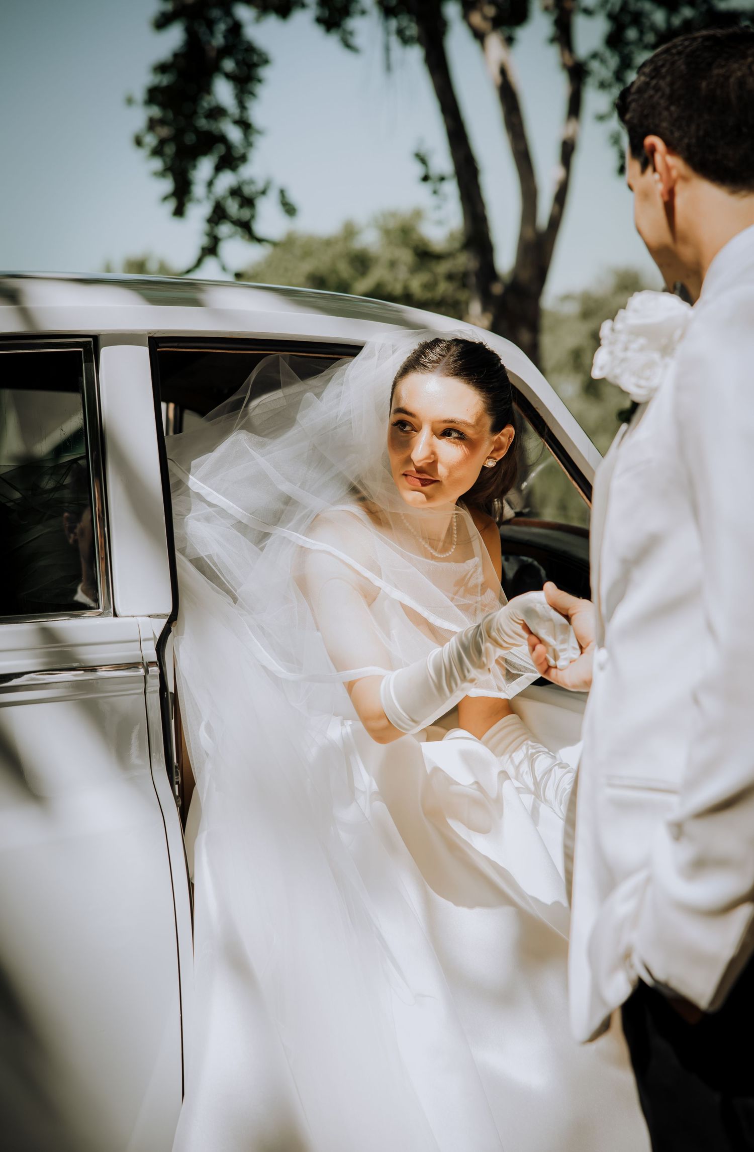 A series showing a bride in white being helped into a classic car.