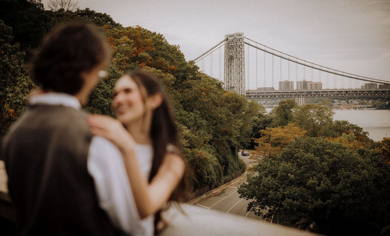Scenic view of a bridge with trees and buildings in the background.