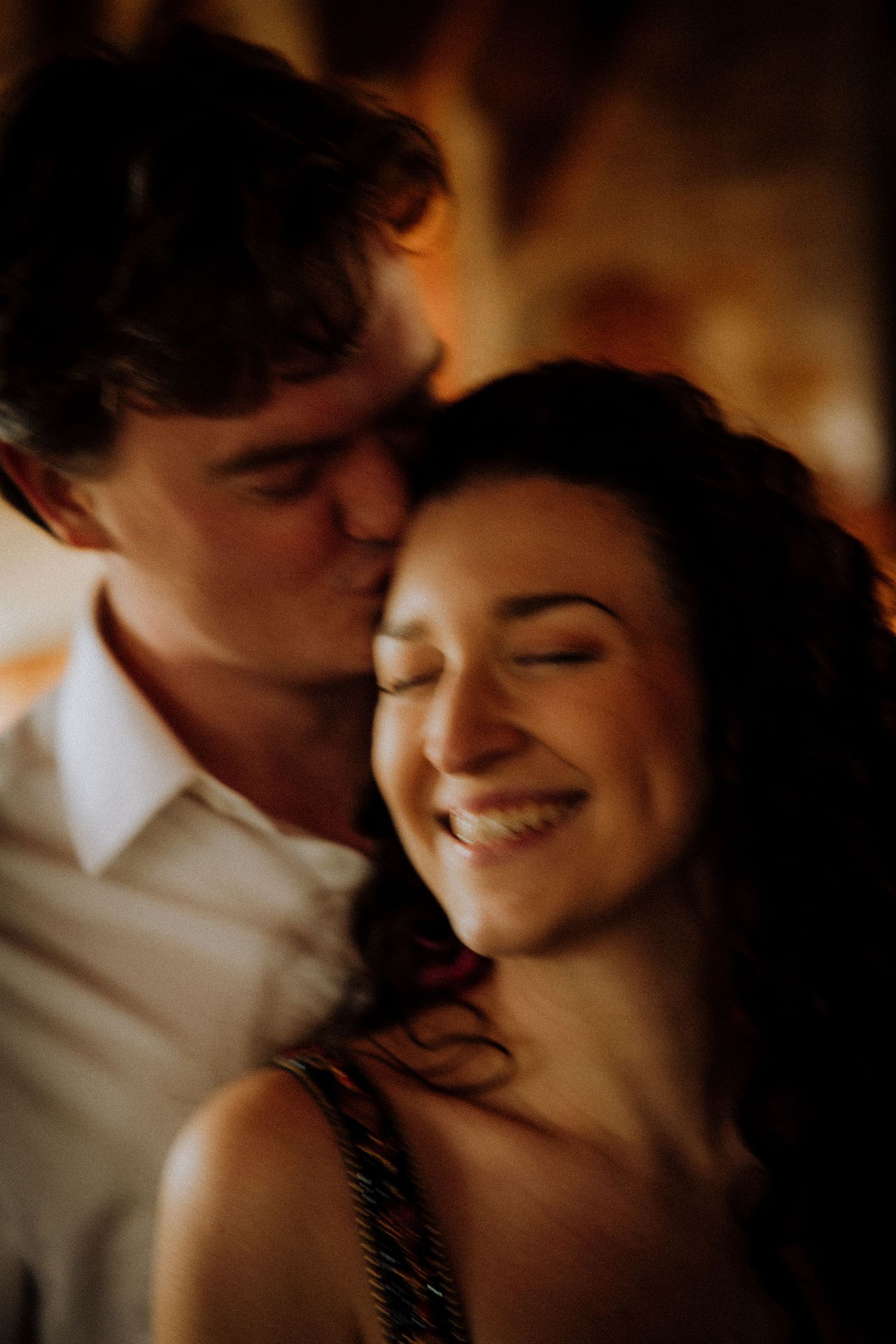 An intimate close-up moment captured in warm, moody lighting.