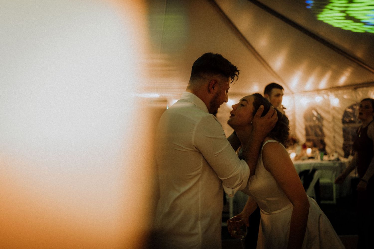 Intimate dance moment at wedding reception with soft focus and warm lighting.