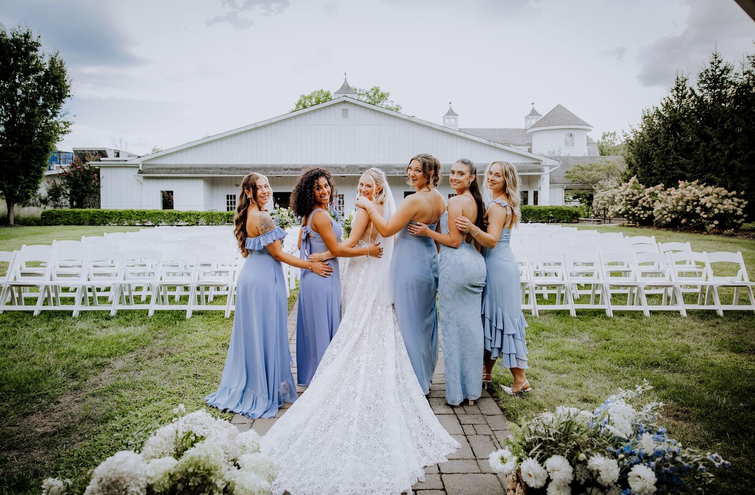 Wedding ceremony setup with white chairs and gazebo against a cloudy sky.Editorial and Cinematic Wedding photos