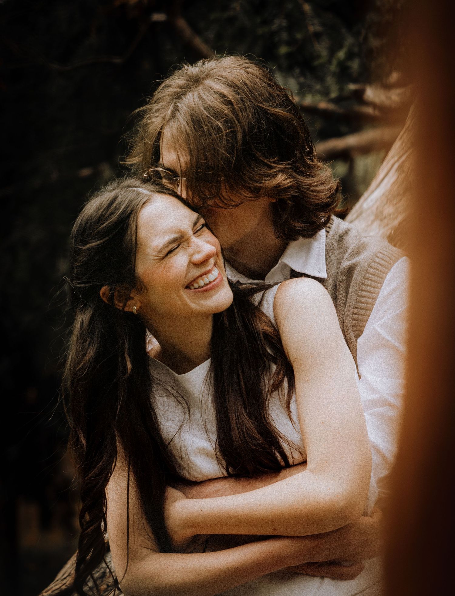 Candid moment of laughter and connection in warm autumn light.