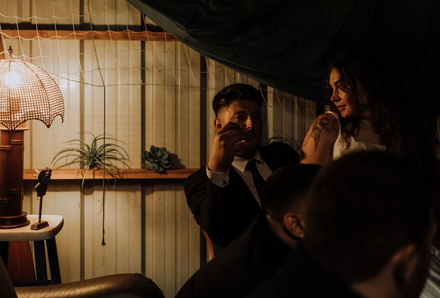 Dimly lit reception venue with guests dancing in silhouette.
