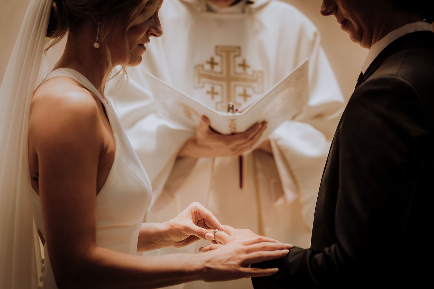 A couple shares an intimate moment during their wedding ceremony while signing documents.