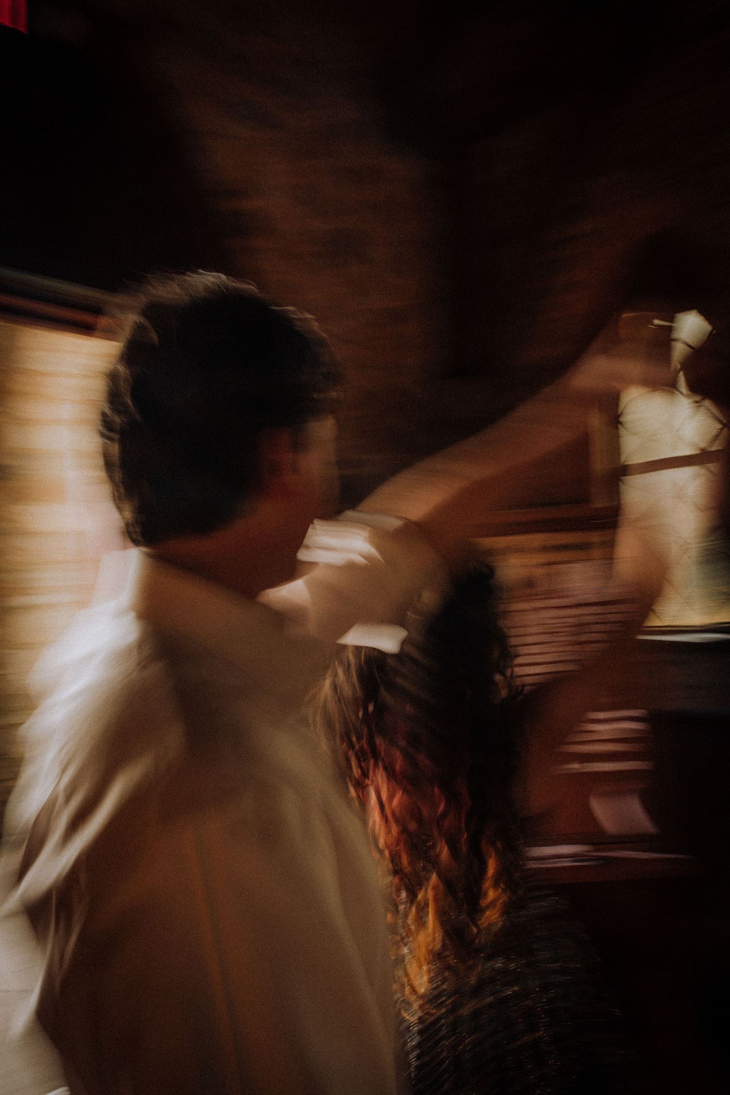 A motion-blurred dance sequence captured in warm tones against a dark background.
