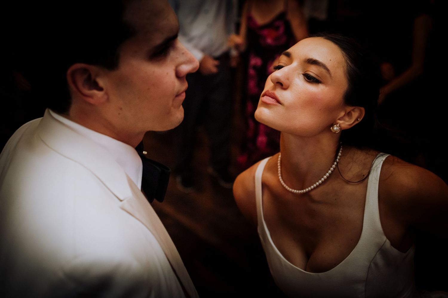 Intimate moment between newlyweds during their first dance at a dimly lit reception.