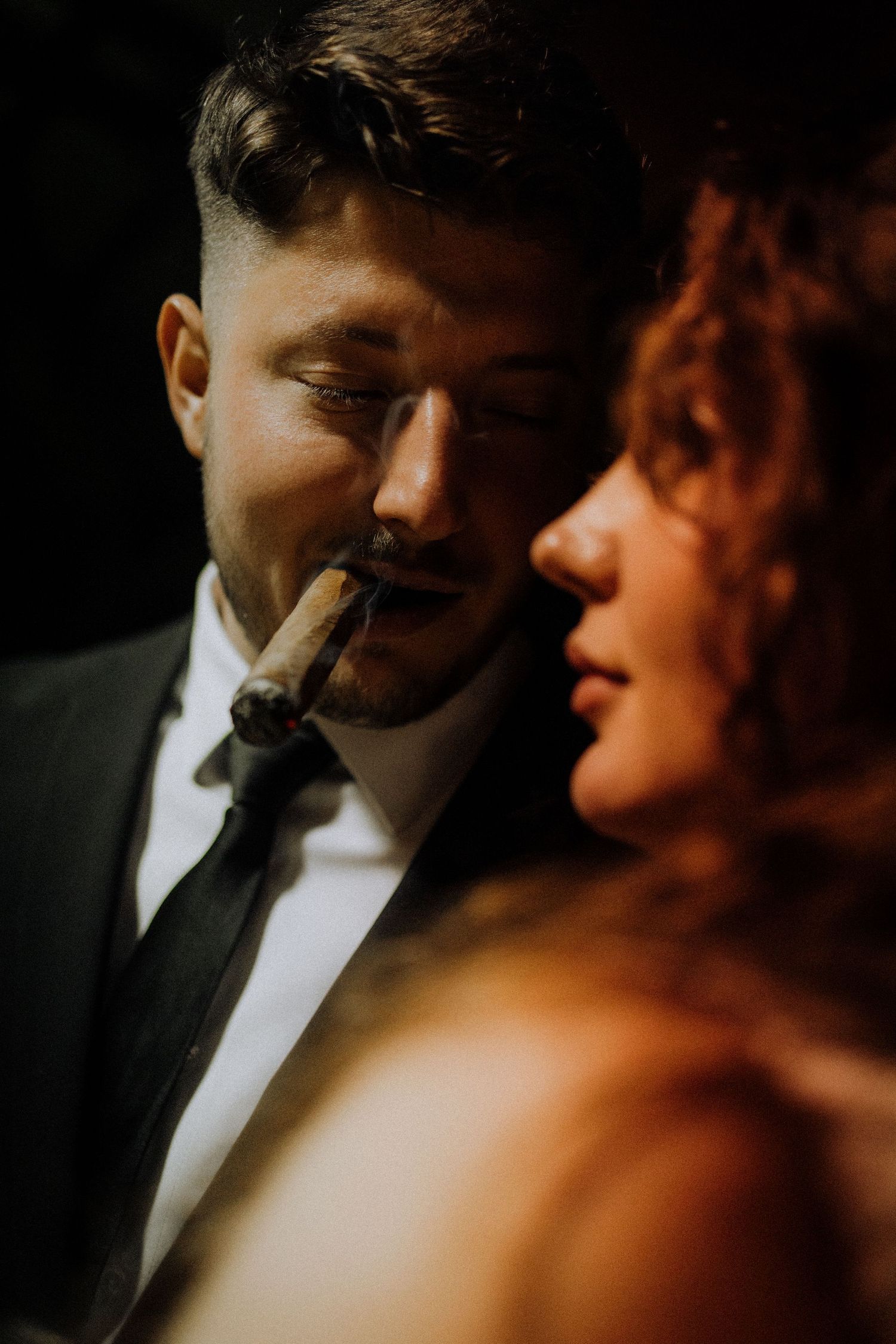Intimate low-light portrait capturing romantic wedding moment.