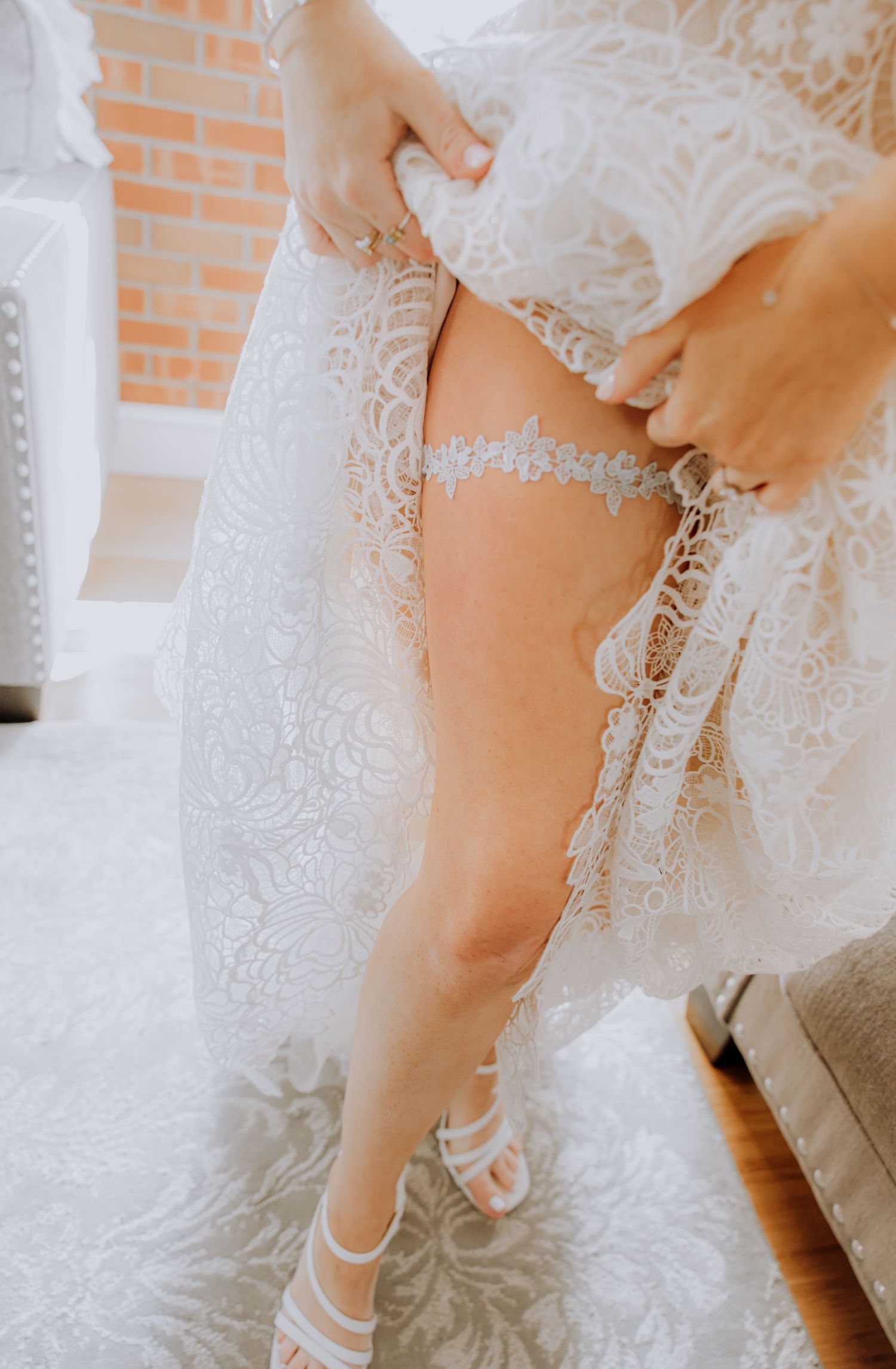 Close-up details of a bride's white lace dress and elegant heels during wedding preparations.Editorial and Cinematic Wedding photos