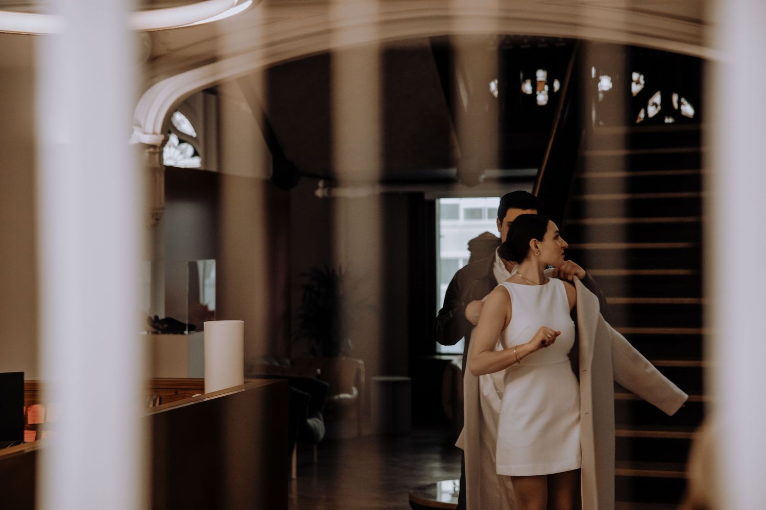 Romantic dance scene in a grand hallway with decorative arches and columns.