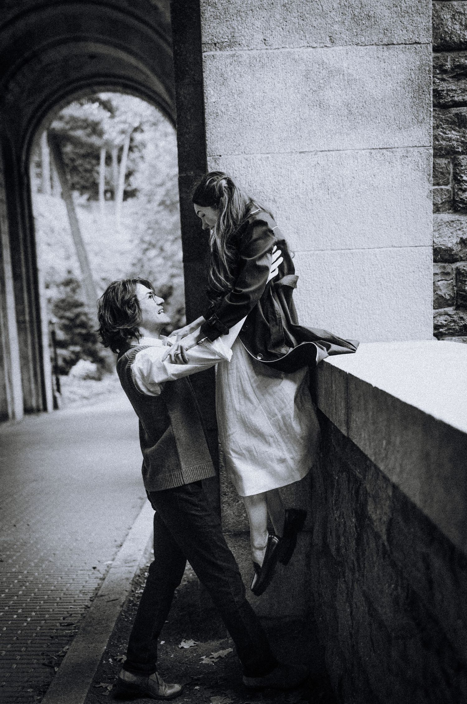Artistic black and white photo of figures in an architectural passageway.