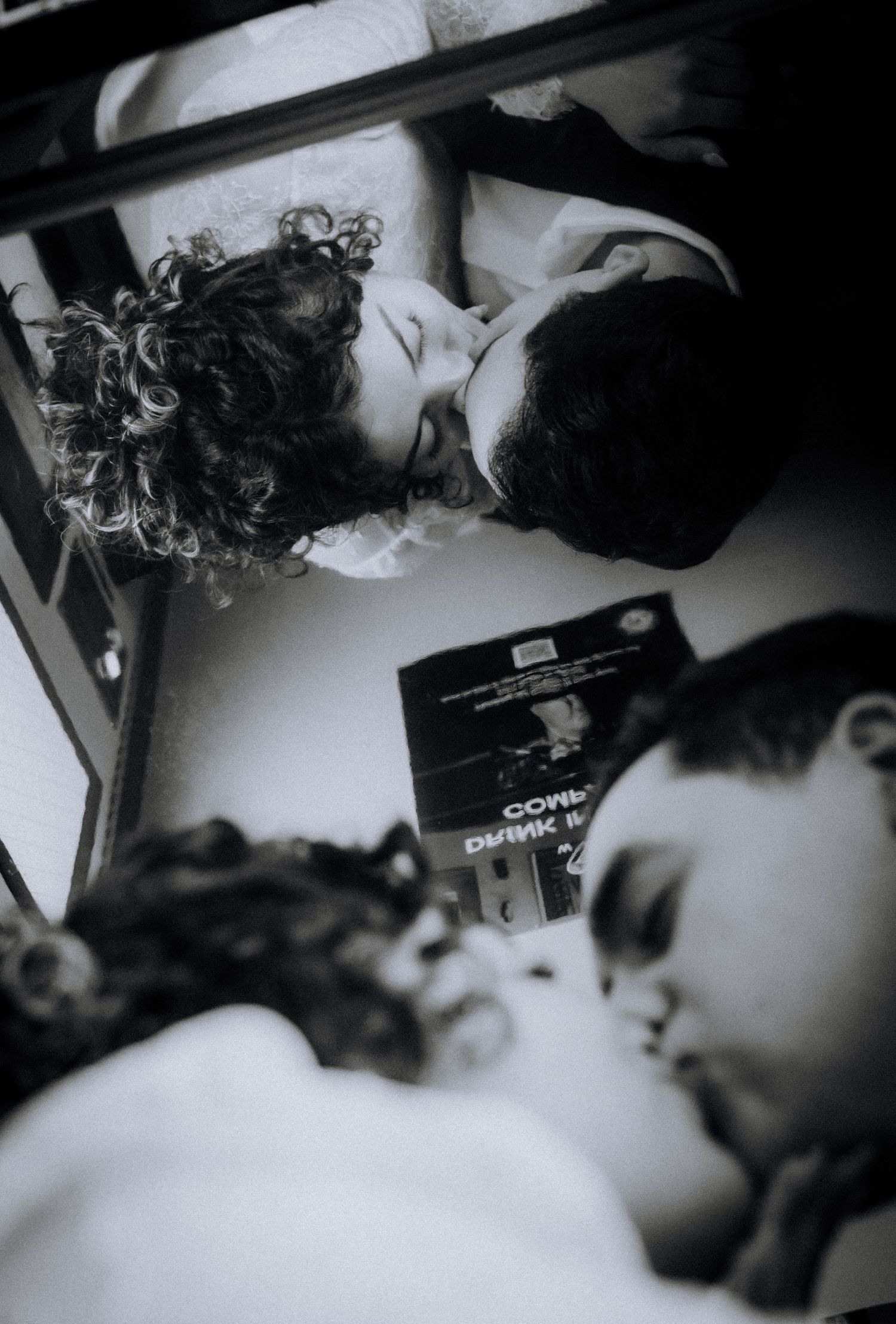Black and white photo of children reading a book together, shot from above at an angle.downtown-los-angeles-engagement-session
