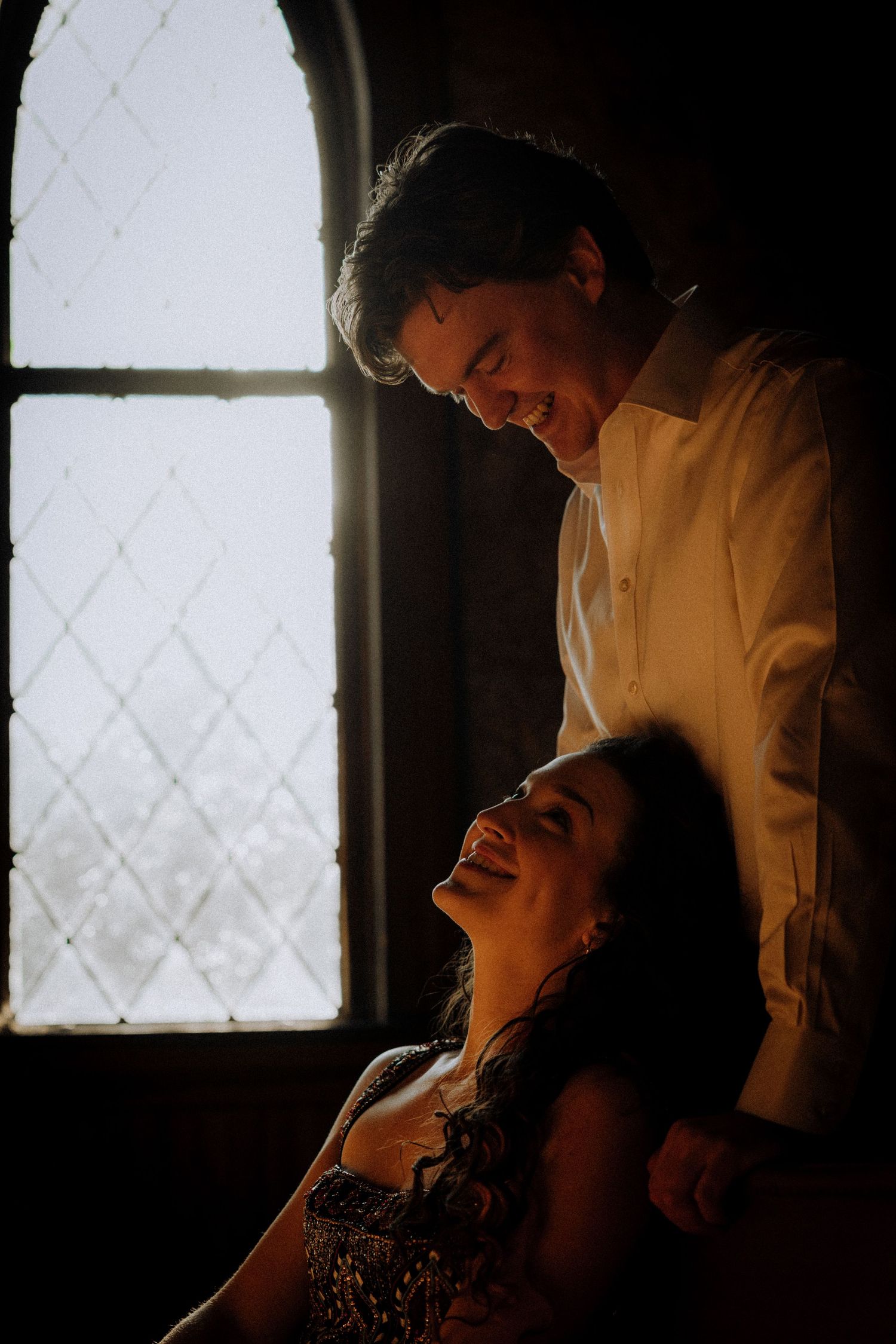 A romantic moment shared in front of a church window.