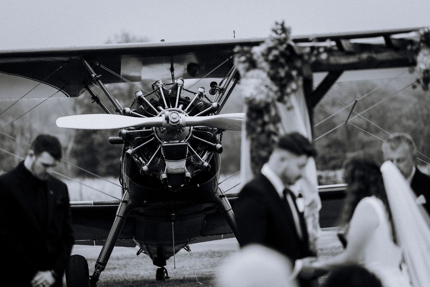 Vintage-style black and white photo of small aircraft on wedding day.