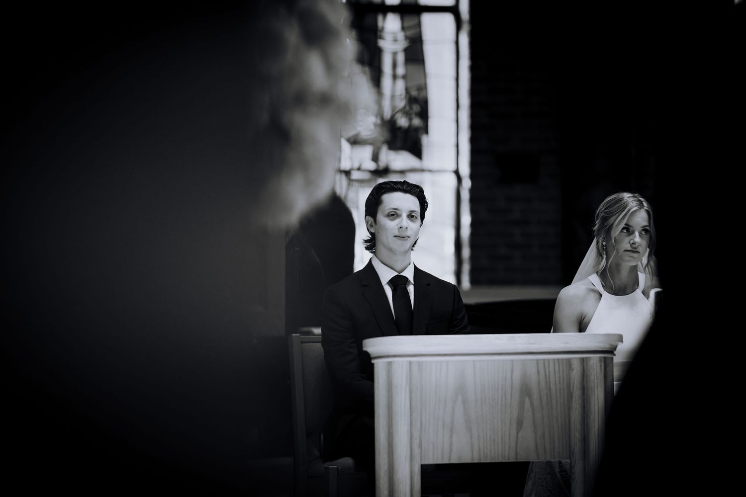A black and white candid shot during a church wedding ceremony.Editorial and Cinematic Wedding photos