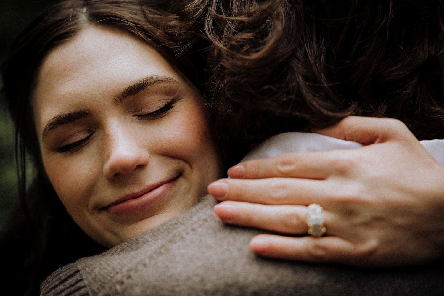 Gentle moment showing hands and soft smiles in natural light.