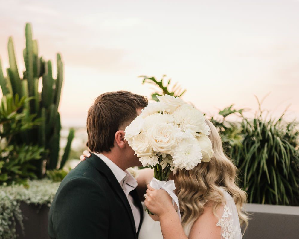 A wedding couple shares intimate moments with their pets during an outdoor garden ceremony.