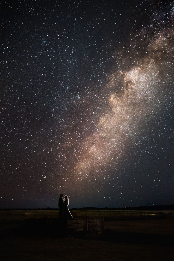 Stunning Milky Way galaxy stretches across dark night sky over silhouetted landscape.
