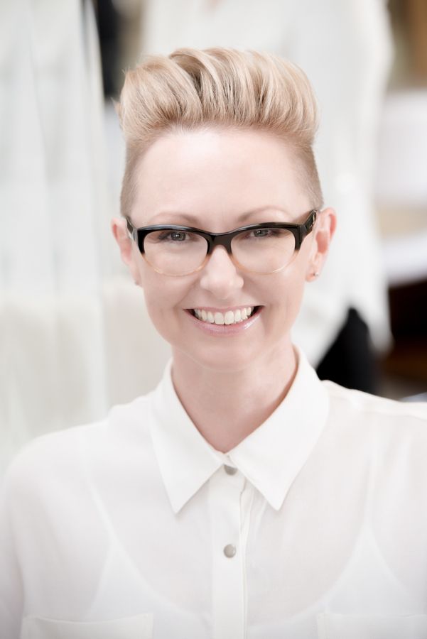 Professional in white collared shirt and glasses photographed in bright high-key style.