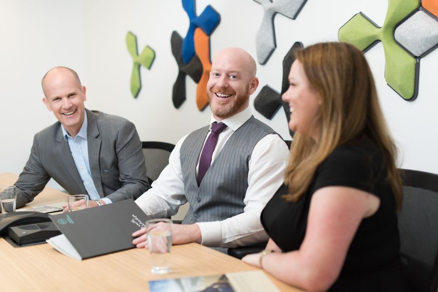 Business team having a discussion around a conference table in a modern office setting.