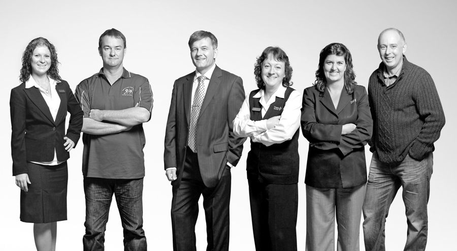 Black and white group business portrait lineup against white background.