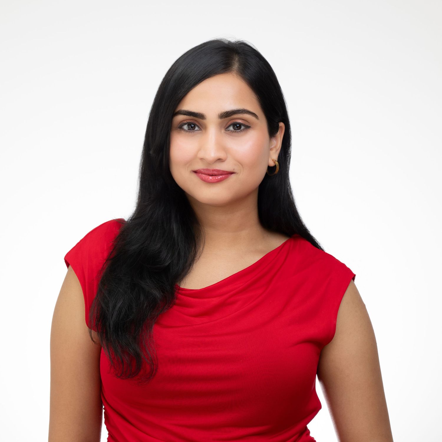 Professional headshot of someone in a red sleeveless top against a white background.