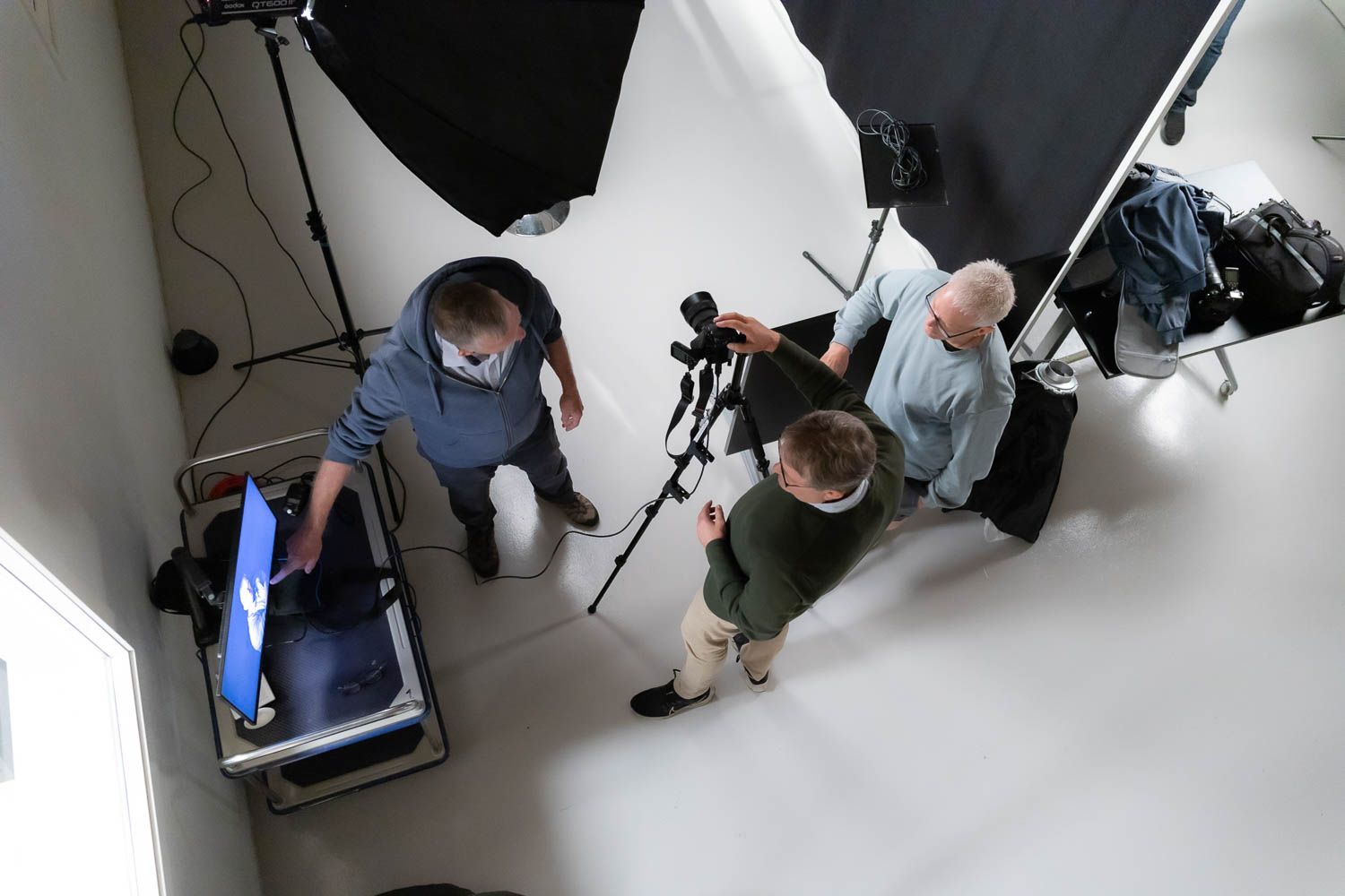 Multiple photographers working together during studio shoot with professional equipment.