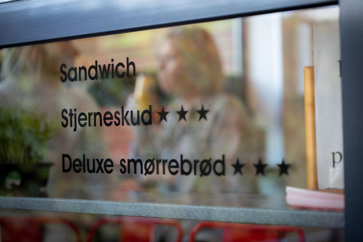 Restaurant menu signage displaying sandwich and deluxe food items with star ratings.