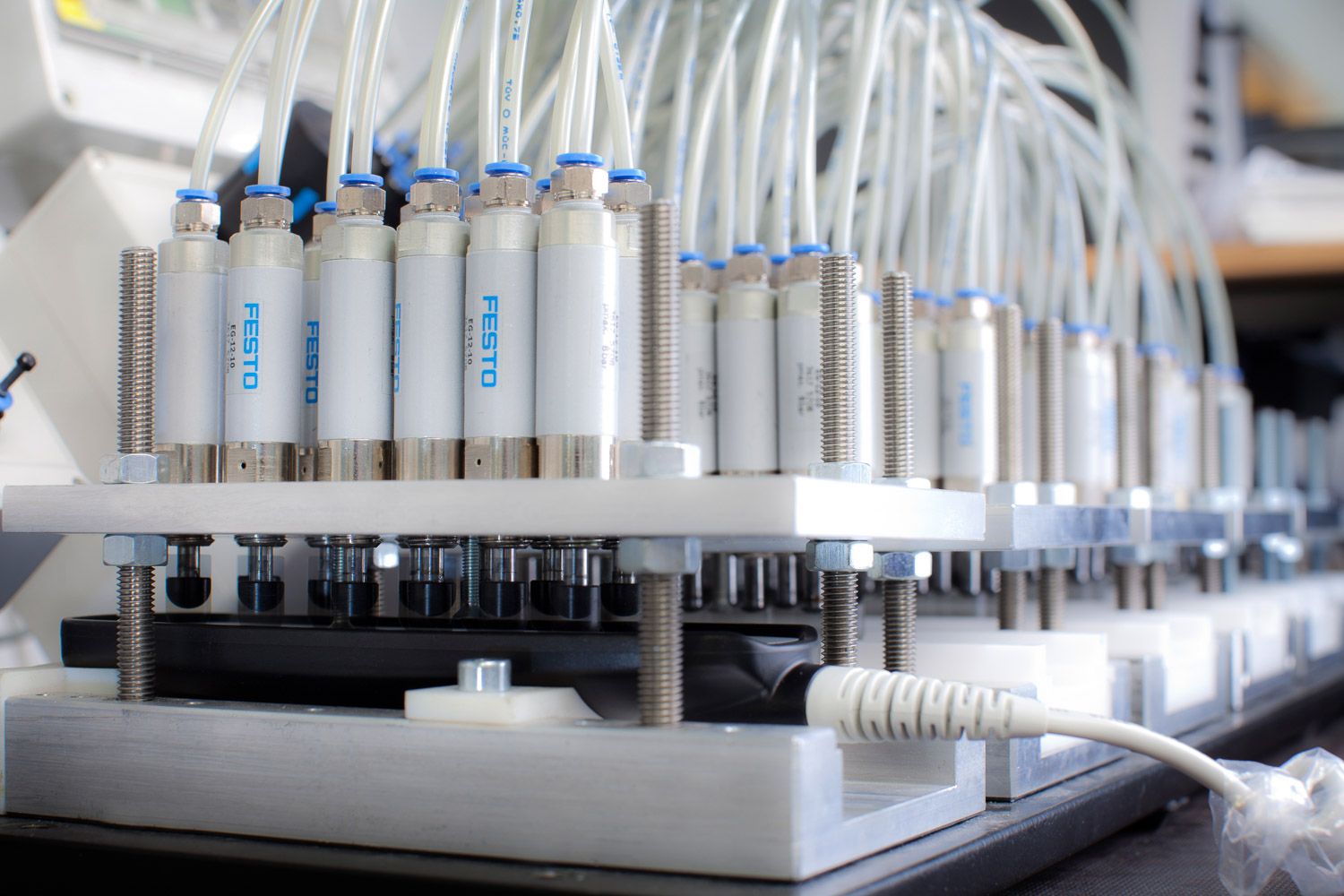 Laboratory setup with multiple test tubes and processing equipment in white rack.