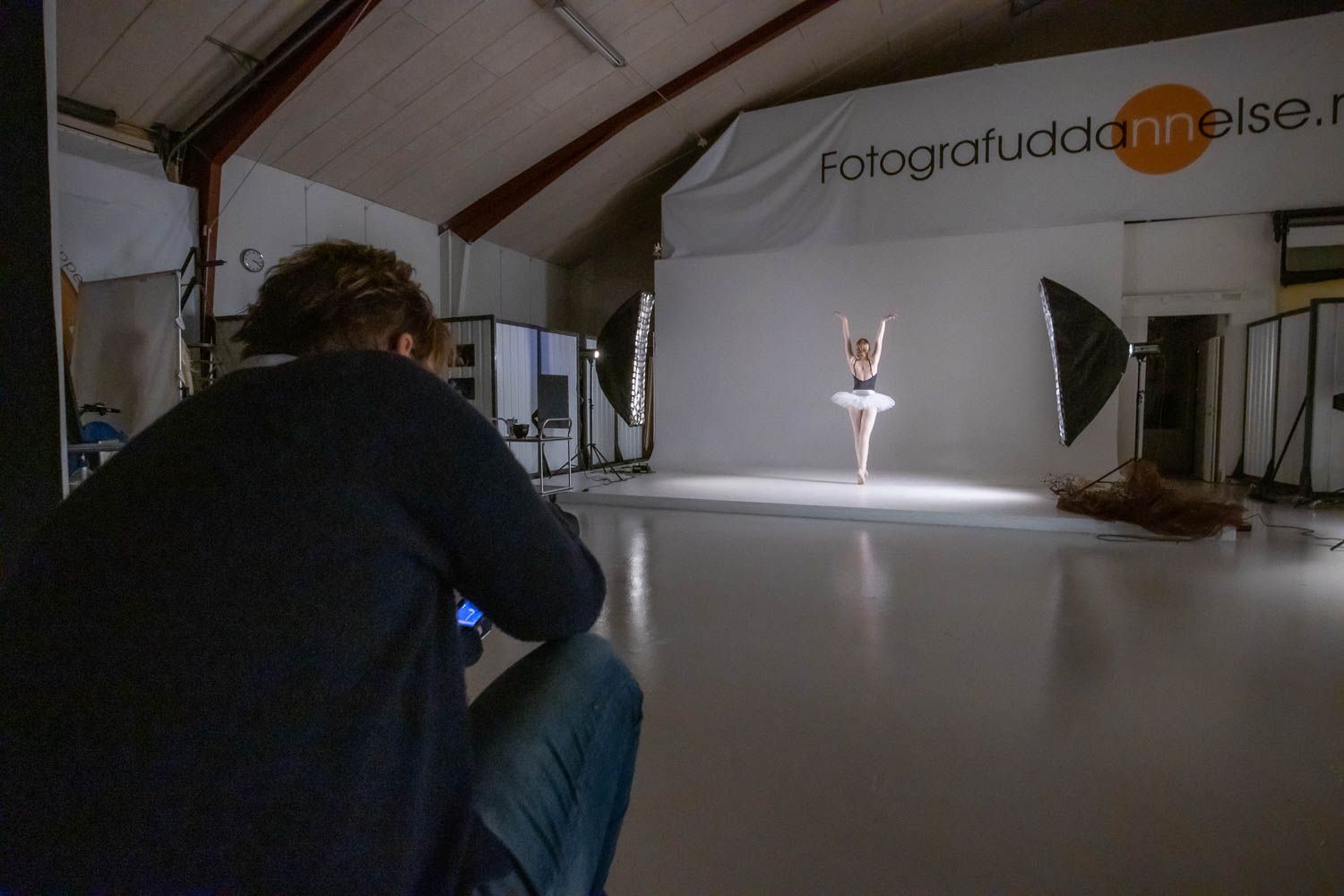 Photography studio interior with professional lighting setup and branded wall signage.