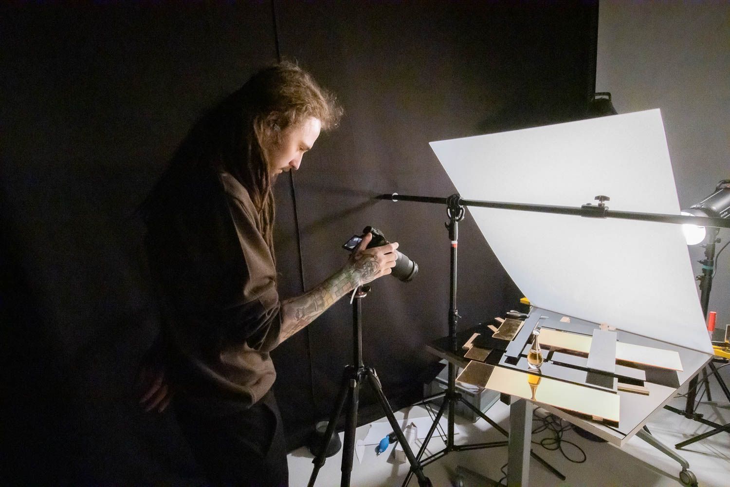 Low-key studio lighting setup showing photographer working with professional equipment.