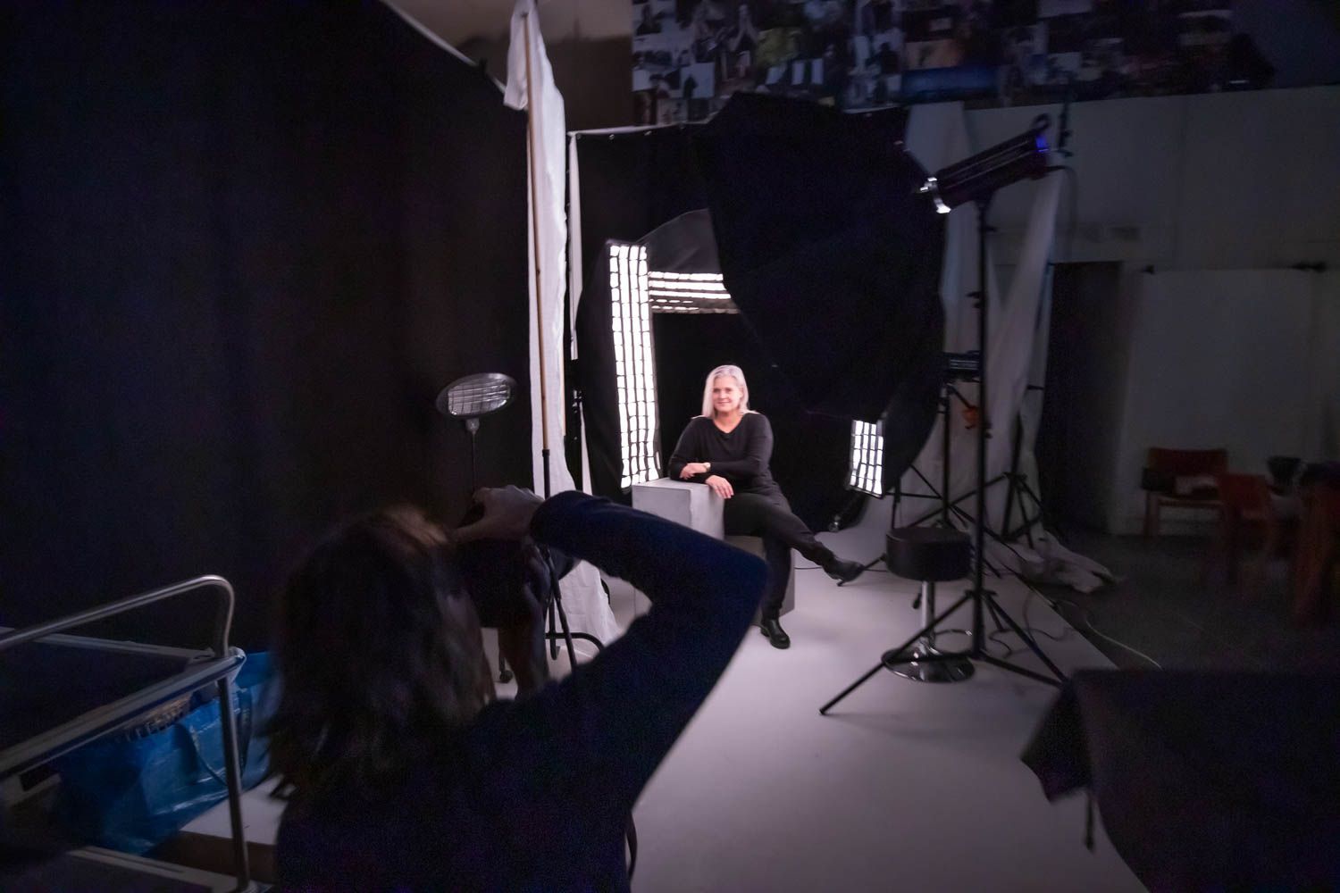 Dimly lit photography studio showing various lighting setups and equipment.